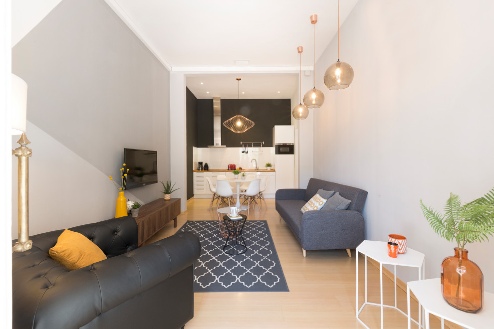 This is an example of a medium sized scandi open plan living room in Barcelona with grey walls, a wall mounted tv and beige floors.