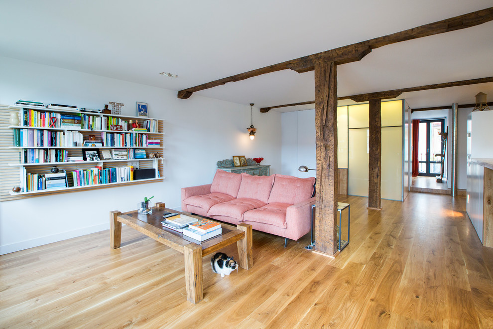 Immagine di un soggiorno contemporaneo di medie dimensioni e aperto con libreria, pareti bianche, pavimento in legno massello medio e nessun camino