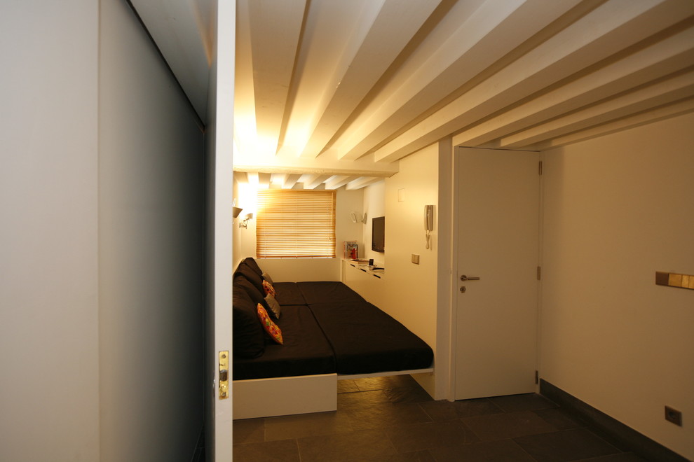 Cette photo montre un petit salon moderne avec un mur blanc et un téléviseur fixé au mur.