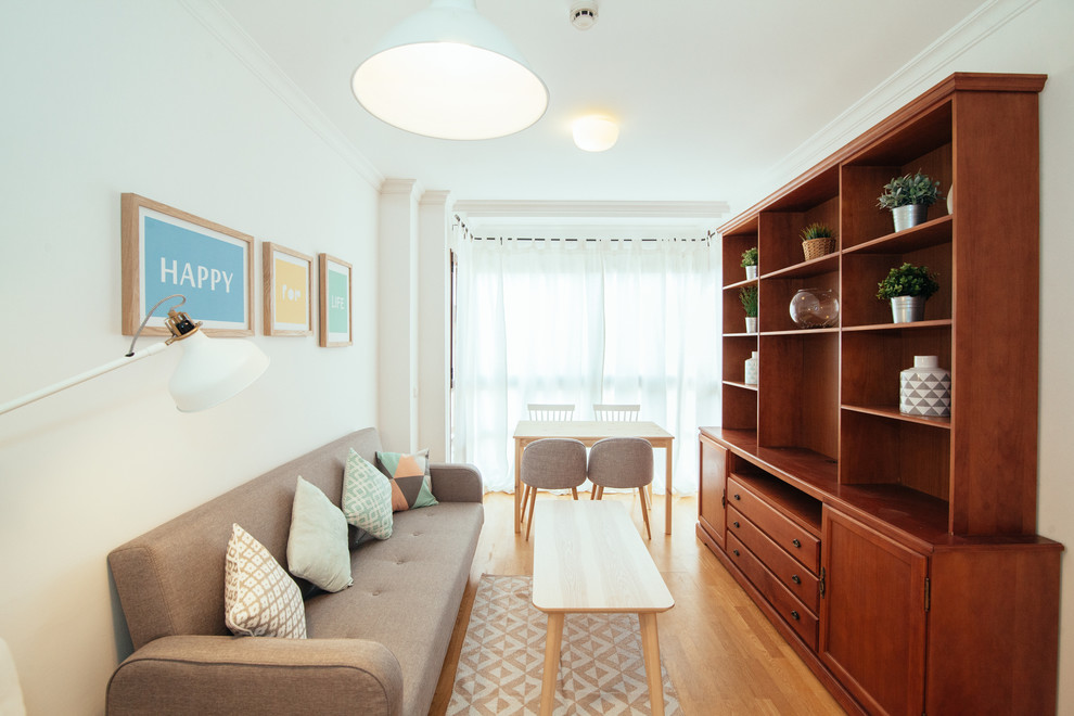Diseño de salón para visitas cerrado escandinavo pequeño sin chimenea y televisor con paredes blancas y suelo de madera en tonos medios