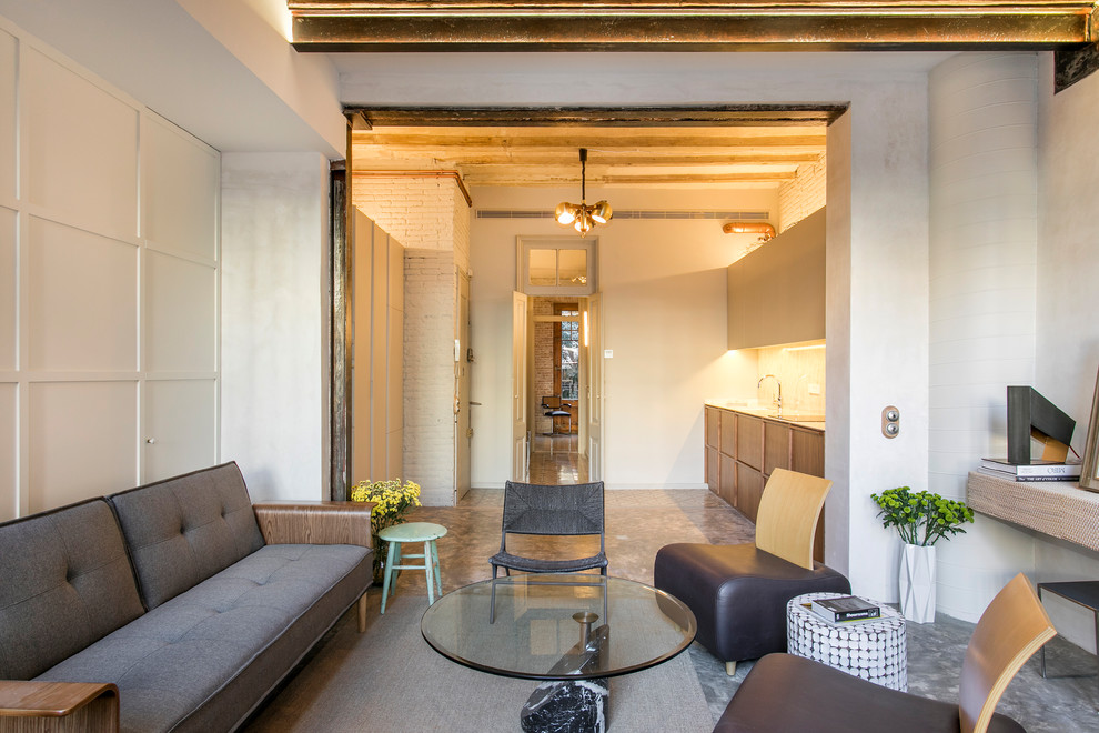 Offenes Industrial Wohnzimmer mit weißer Wandfarbe, Betonboden und grauem Boden in Barcelona