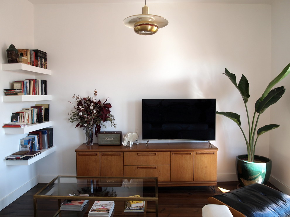 Wohnzimmer mit weißer Wandfarbe, dunklem Holzboden und braunem Boden in Madrid