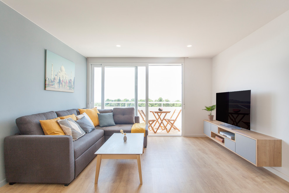 Diseño de salón cerrado nórdico con paredes blancas, suelo de madera clara, televisor independiente y suelo beige