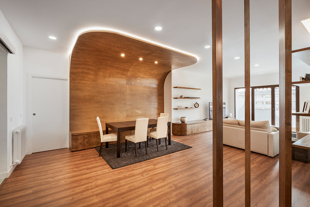 Inspiration pour une salle à manger design avec un mur blanc, un sol en bois brun, aucune cheminée et un sol marron.