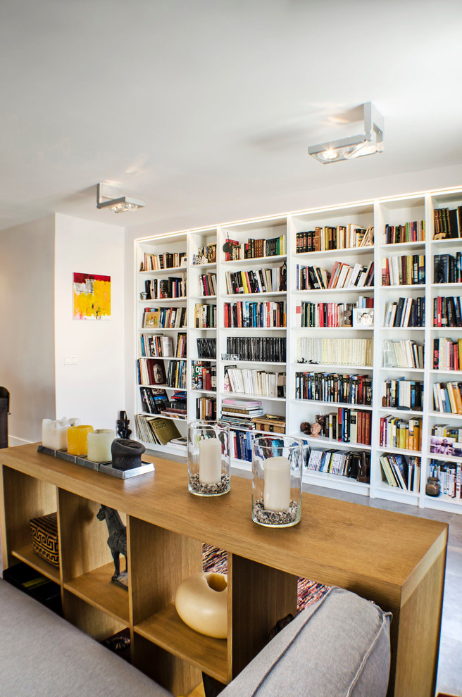 Ejemplo de biblioteca en casa abierta contemporánea de tamaño medio sin chimenea con paredes blancas y suelo de baldosas de cerámica