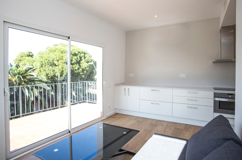 Mittelgroßes, Offenes Modernes Wohnzimmer ohne Kamin mit beiger Wandfarbe, braunem Holzboden und braunem Boden in Barcelona