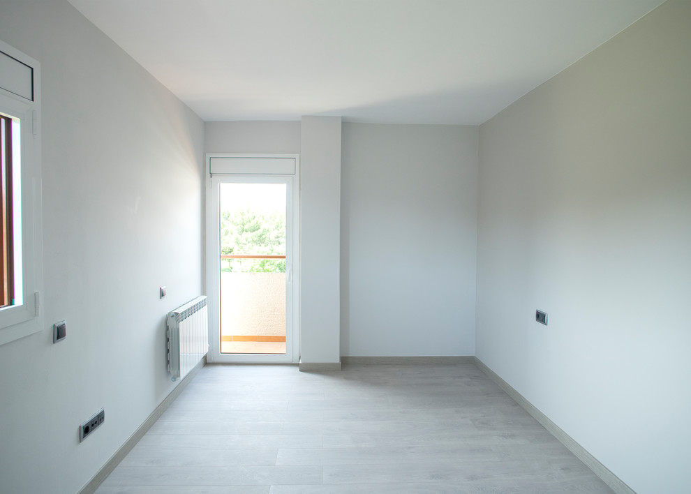 Свежая идея для дизайна: изолированная гостиная комната среднего размера в стиле модернизм с белыми стенами, светлым паркетным полом и коричневым полом без камина - отличное фото интерьера
