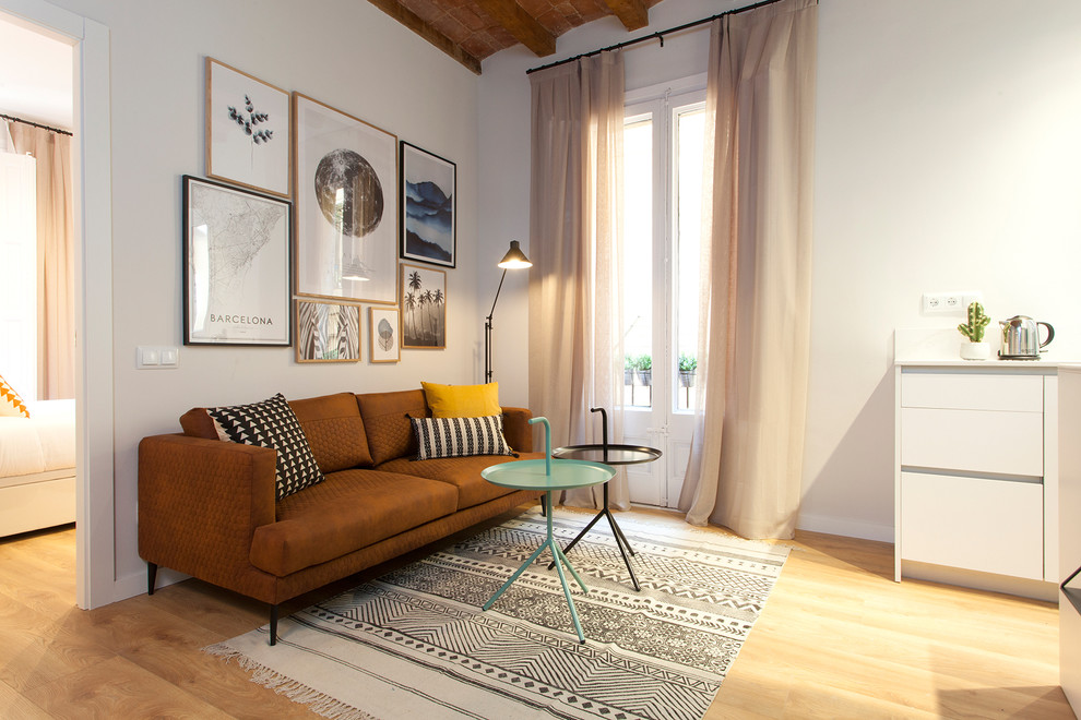 Diseño de salón abierto minimalista pequeño sin chimenea con suelo de madera en tonos medios, televisor colgado en la pared, suelo marrón y paredes azules