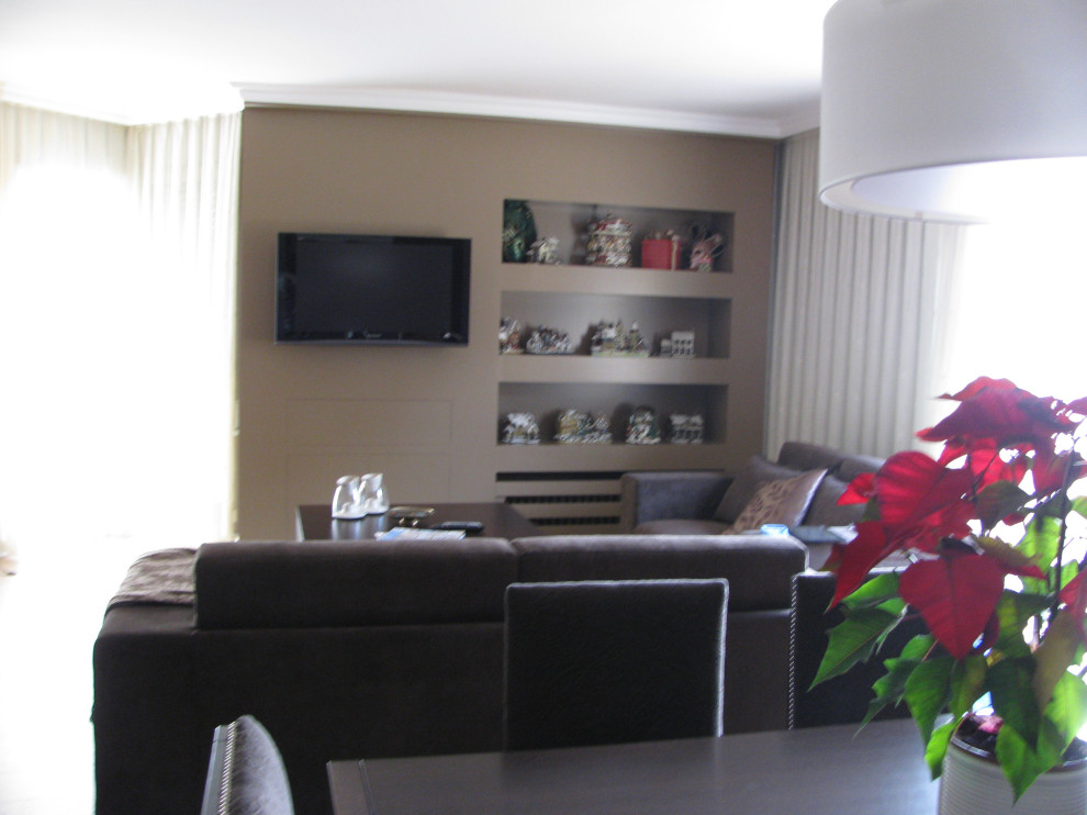 Esempio di un soggiorno contemporaneo con pareti marroni, TV a parete e pavimento beige