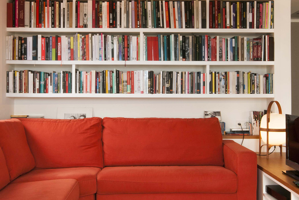 Exempel på ett mellanstort minimalistiskt separat vardagsrum, med ett bibliotek, vita väggar och en fristående TV