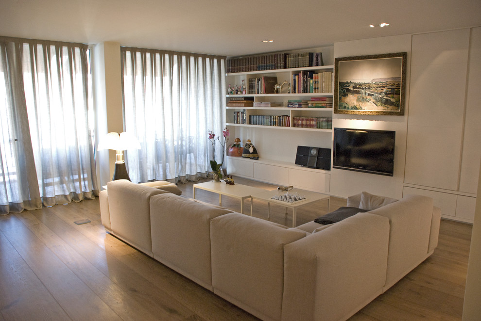 バルセロナにある高級な中くらいなトランジショナルスタイルのおしゃれなLDK (ライブラリー、白い壁、無垢フローリング、暖炉なし、壁掛け型テレビ、茶色い床) の写真