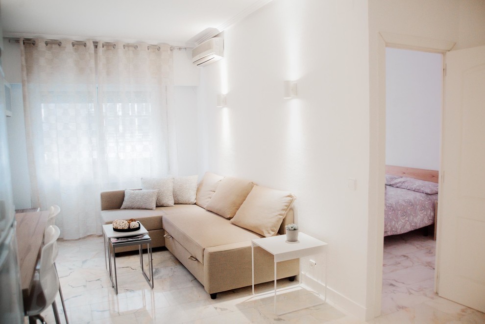 Kleines, Offenes Nordisches Wohnzimmer ohne Kamin mit weißer Wandfarbe, Marmorboden, freistehendem TV und weißem Boden in Madrid