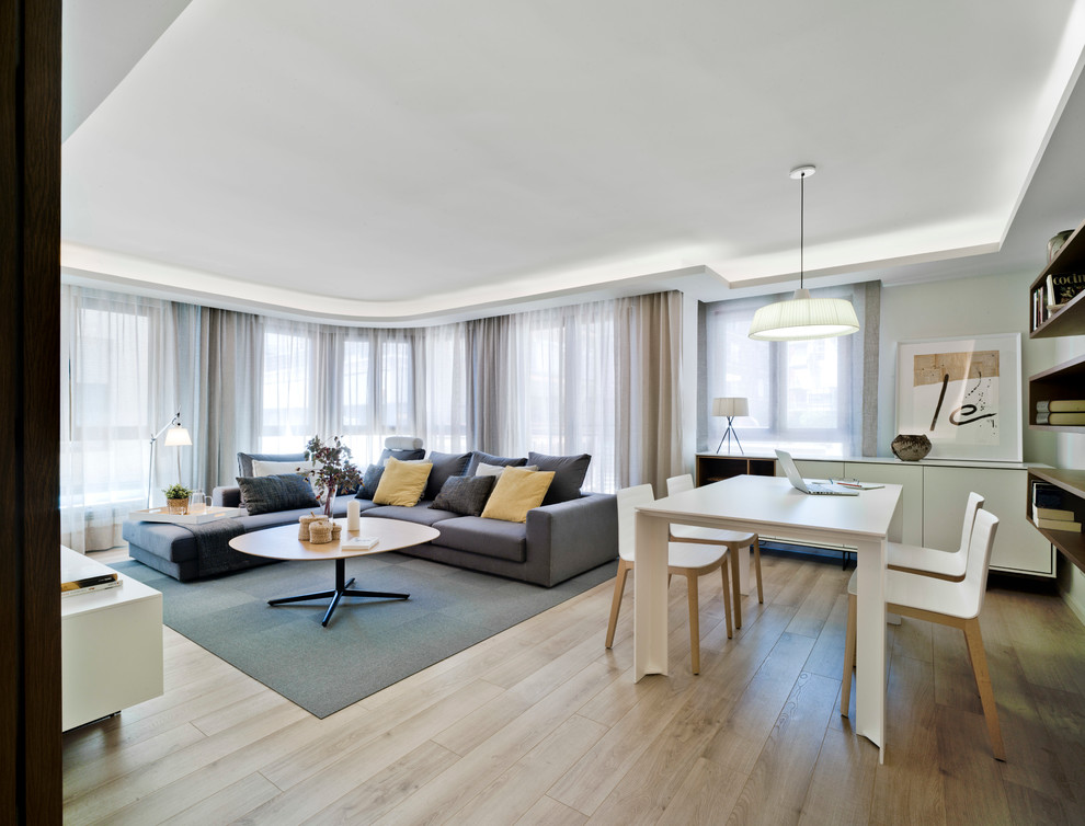 Modelo de salón para visitas abierto actual con paredes blancas y suelo de madera clara