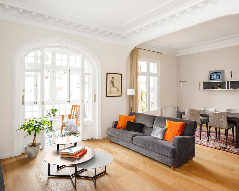 Imagen de salón abierto actual con paredes blancas, suelo de madera en tonos medios y suelo marrón
