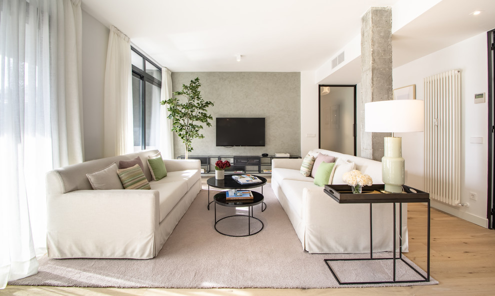 Modernes Wohnzimmer mit weißer Wandfarbe, braunem Holzboden, TV-Wand und braunem Boden in Madrid