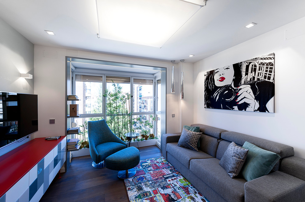 Пример оригинального дизайна: маленькая открытая, парадная гостиная комната в стиле фьюжн с серыми стенами, темным паркетным полом и телевизором на стене для на участке и в саду