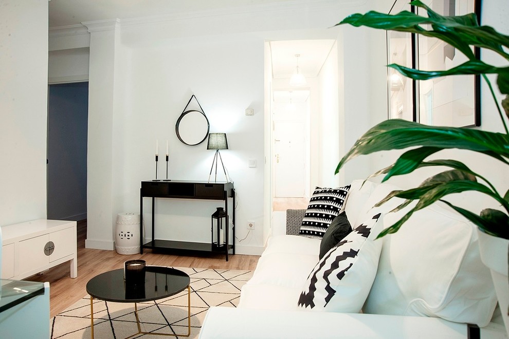 Idee per un soggiorno nordico di medie dimensioni e chiuso con pareti bianche, pavimento in legno massello medio, parete attrezzata e pavimento marrone