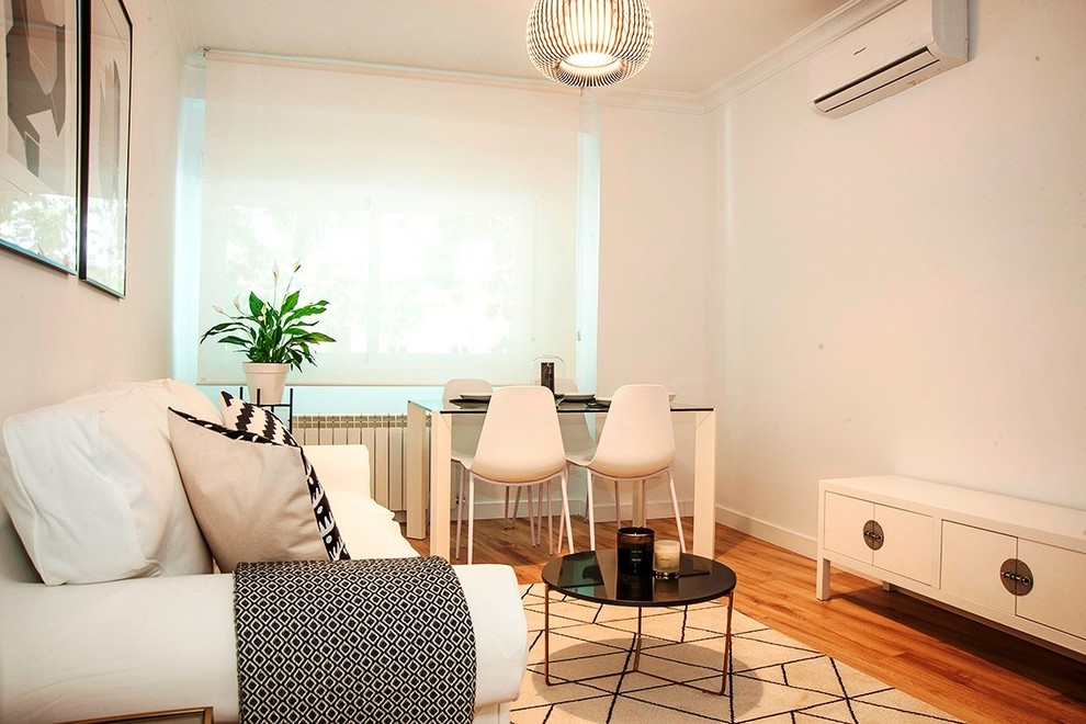На фото: изолированная гостиная комната среднего размера в скандинавском стиле с белыми стенами, паркетным полом среднего тона, мультимедийным центром и коричневым полом