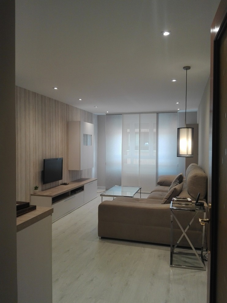 Пример оригинального дизайна: гостиная комната среднего размера в стиле модернизм с с книжными шкафами и полками, бежевыми стенами, полом из ламината, телевизором на стене и бежевым полом
