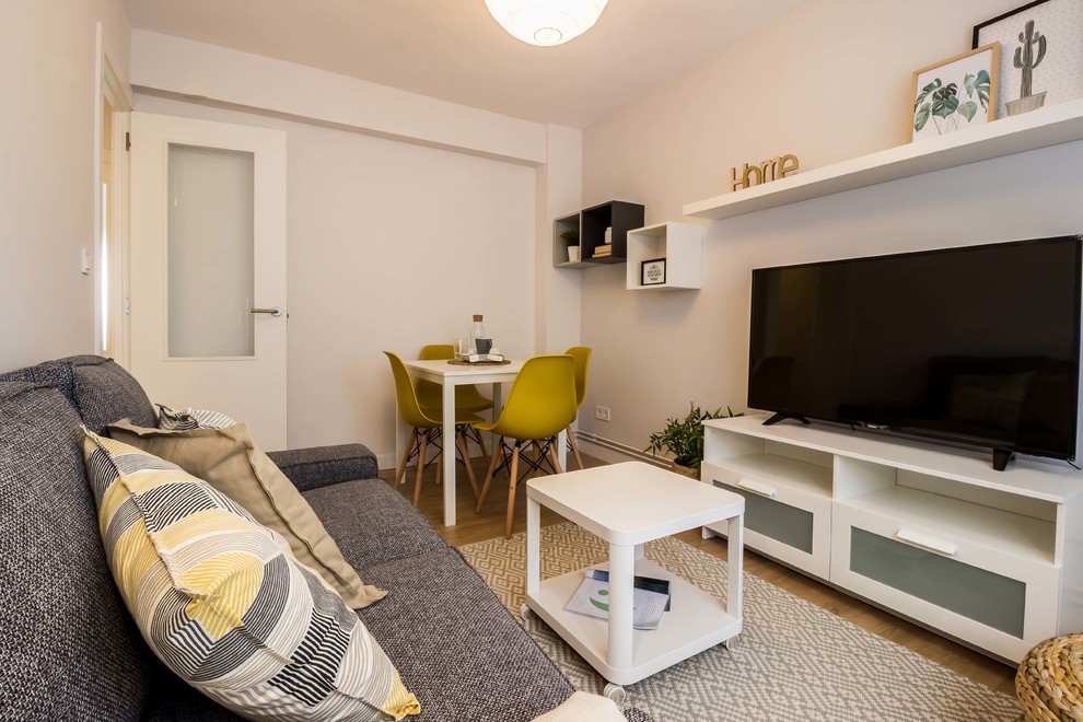 Стильный дизайн: маленькая изолированная гостиная комната в скандинавском стиле с серыми стенами, полом из ламината и коричневым полом для на участке и в саду - последний тренд