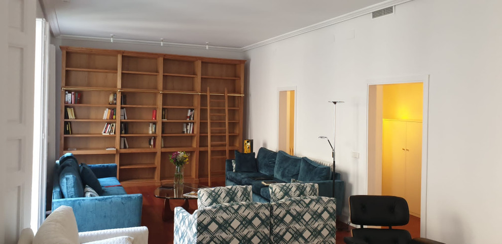 Exemple d'un grand salon chic ouvert avec une bibliothèque ou un coin lecture, un mur blanc, parquet foncé et un sol marron.