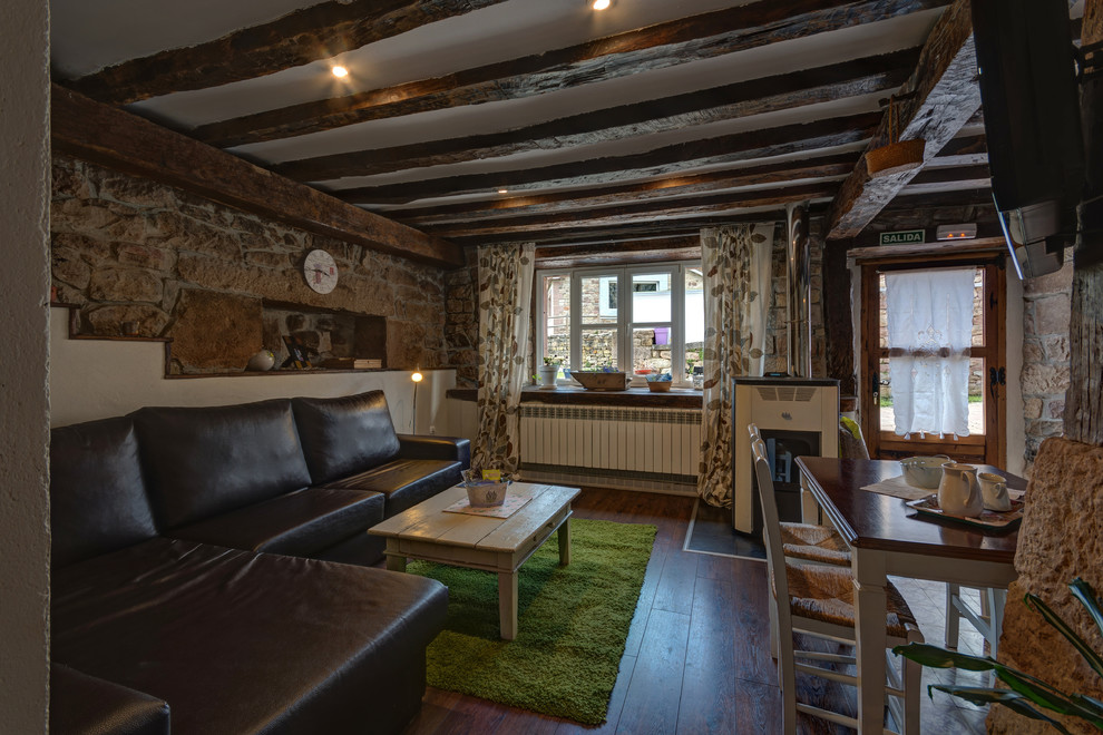 Idee per un piccolo soggiorno stile rurale aperto con TV a parete, sala formale, pareti multicolore, parquet scuro e stufa a legna