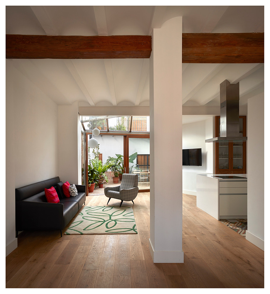 Mittelgroßes, Repräsentatives, Offenes Mediterranes Wohnzimmer ohne Kamin mit weißer Wandfarbe, braunem Holzboden und TV-Wand in Valencia