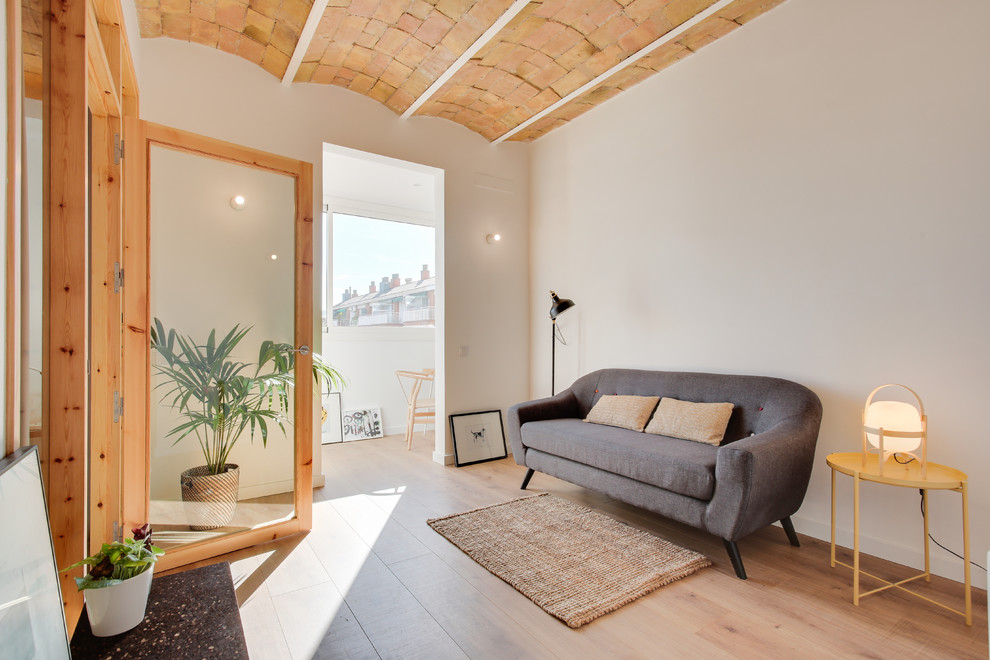 Mediterranes Wohnzimmer mit weißer Wandfarbe und hellem Holzboden in Barcelona