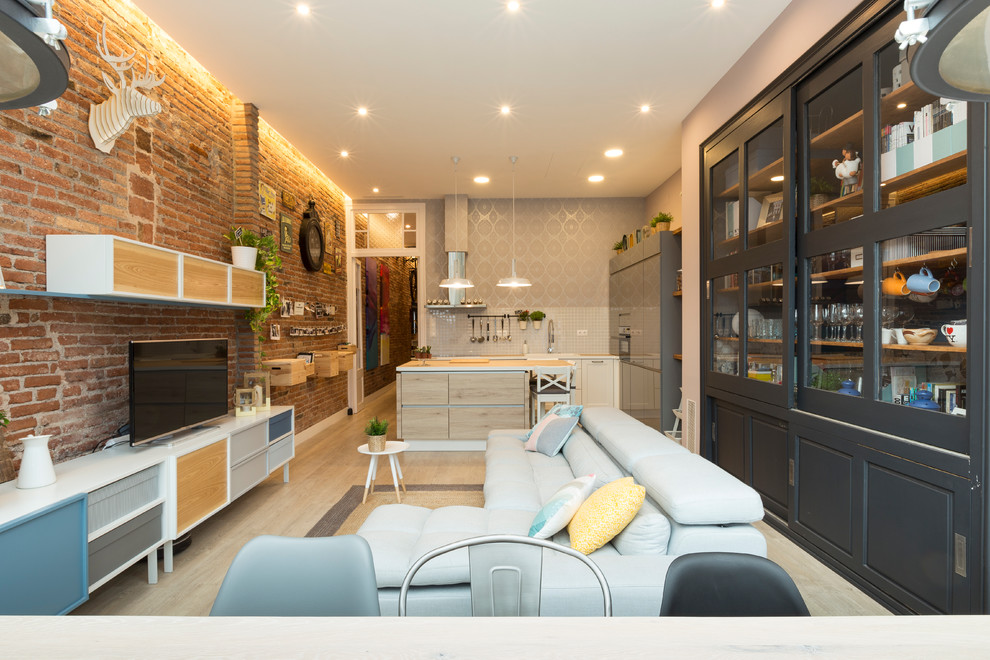 Foto de salón para visitas abierto urbano de tamaño medio con suelo de madera clara y televisor independiente
