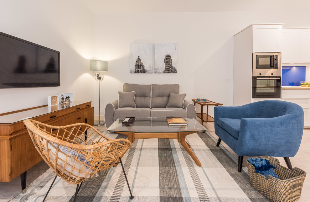 Mittelgroßes, Repräsentatives, Offenes Modernes Wohnzimmer ohne Kamin mit weißer Wandfarbe, hellem Holzboden und TV-Wand in Madrid