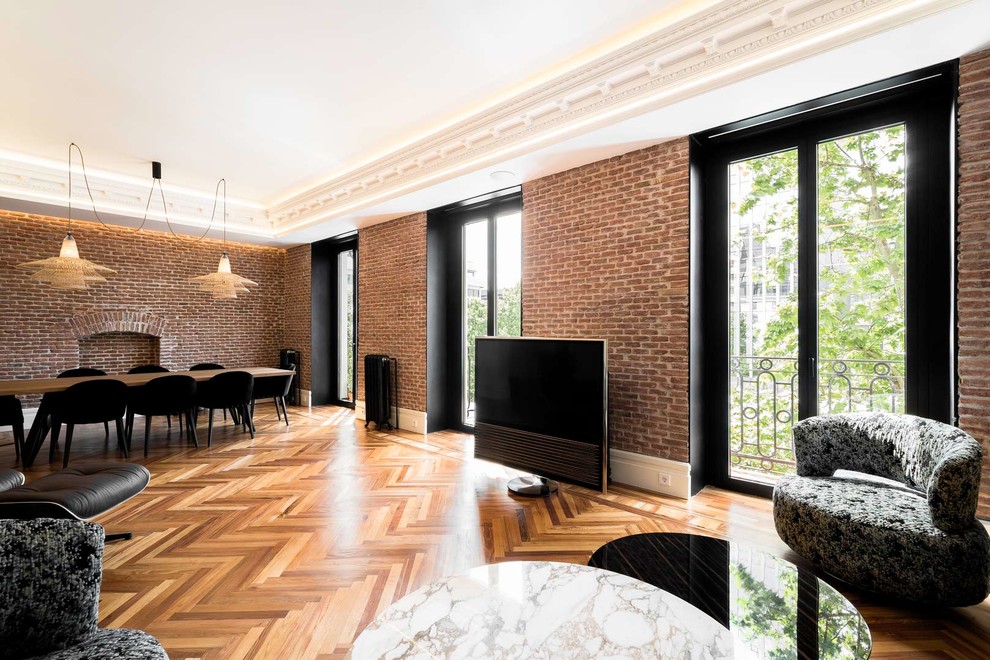 Großes, Offenes Klassisches Wohnzimmer mit weißer Wandfarbe, braunem Holzboden, Hängekamin, freistehendem TV und braunem Boden in Madrid