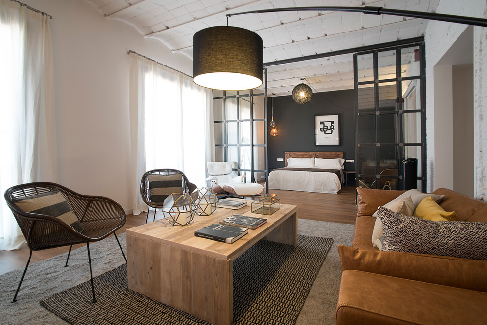 Repräsentatives, Offenes Industrial Wohnzimmer mit weißer Wandfarbe und braunem Holzboden in Barcelona