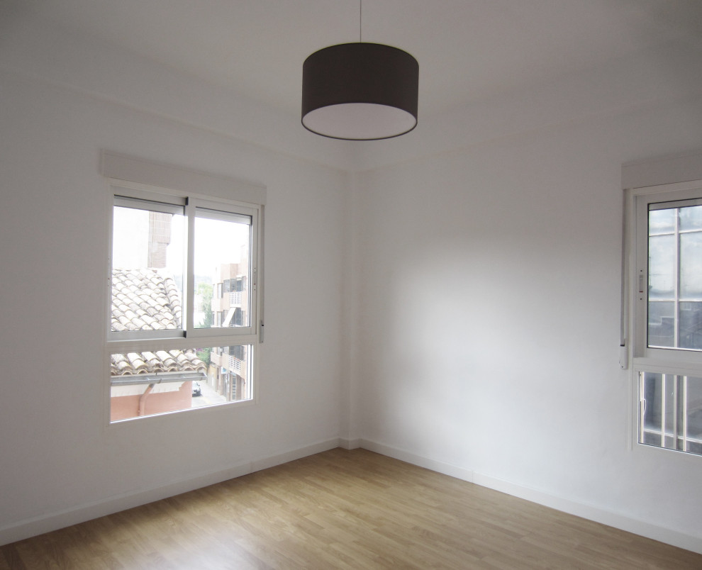 Modelo de salón cerrado nórdico pequeño con paredes blancas, suelo laminado y suelo marrón