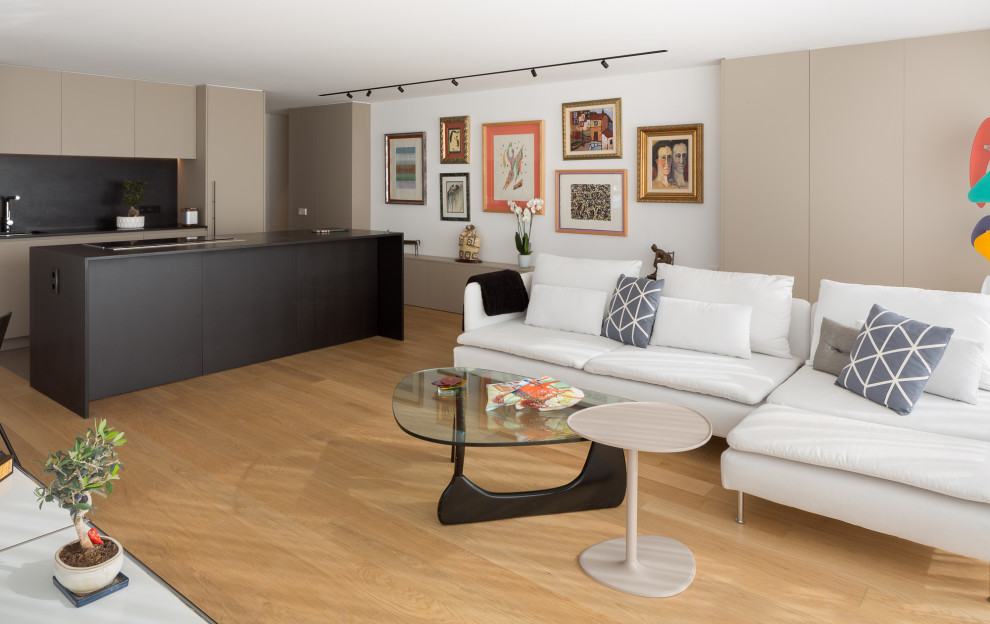 Diseño de salón contemporáneo sin televisor con paredes blancas y suelo de madera clara