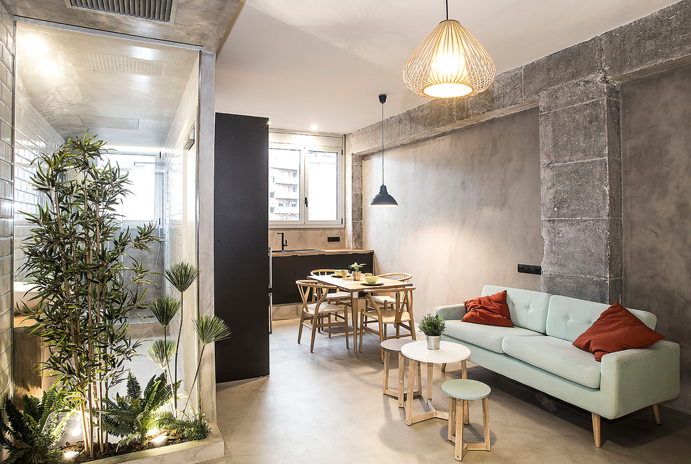 Kleines, Fernseherloses Industrial Wohnzimmer im Loft-Stil, ohne Kamin mit grauer Wandfarbe, grauem Boden und Betonboden in Barcelona