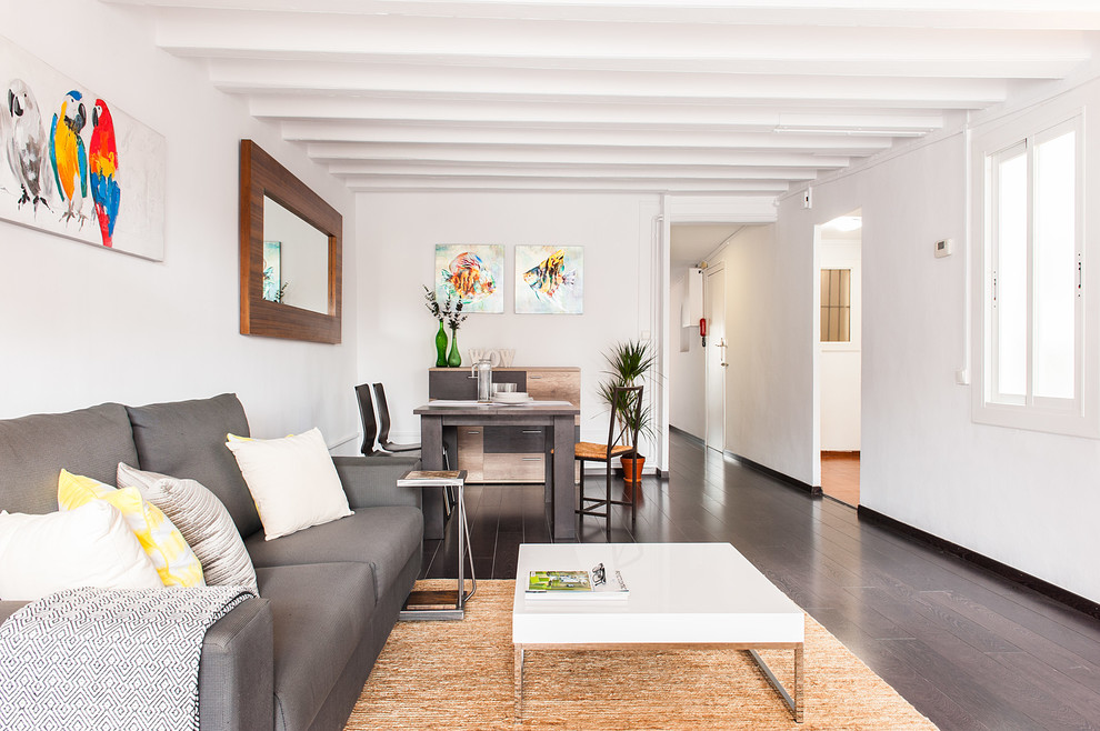 Mittelgroßes, Offenes Modernes Wohnzimmer mit weißer Wandfarbe und dunklem Holzboden in Barcelona