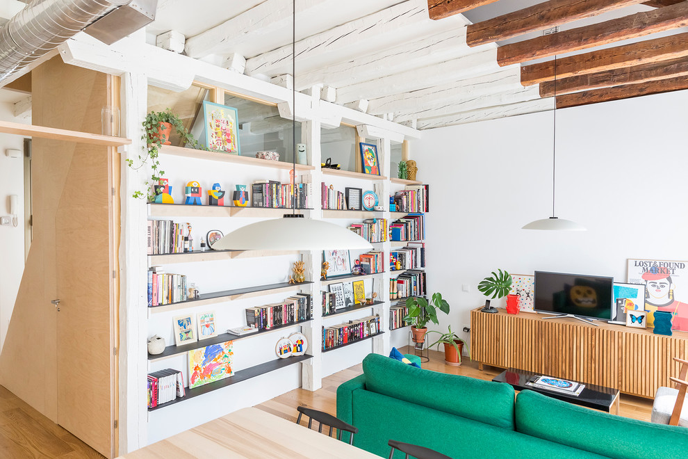 Diseño de biblioteca en casa abierta moderna de tamaño medio con paredes blancas, suelo de madera en tonos medios, televisor independiente y suelo marrón