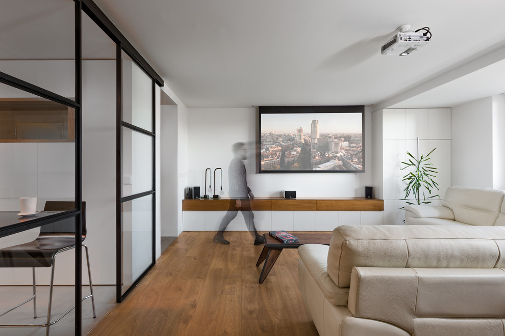 Immagine di un soggiorno design aperto con pareti bianche, pavimento in legno massello medio, nessun camino e pavimento marrone