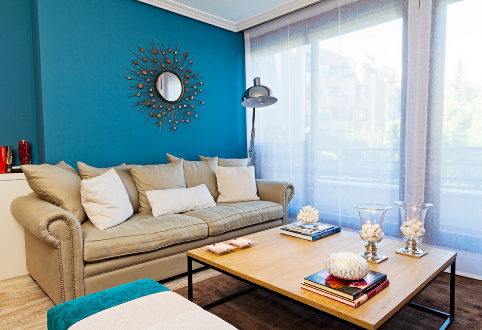 Modelo de salón para visitas abierto bohemio de tamaño medio sin chimenea con paredes azules y suelo de madera en tonos medios
