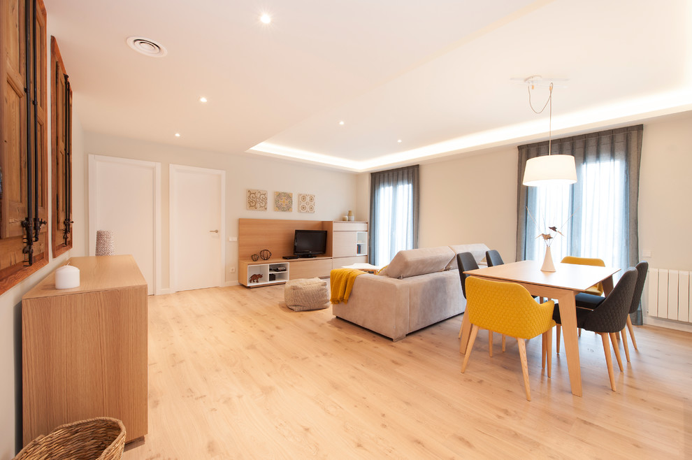Modelo de salón abierto moderno grande con paredes blancas, suelo de madera en tonos medios, televisor independiente y suelo marrón