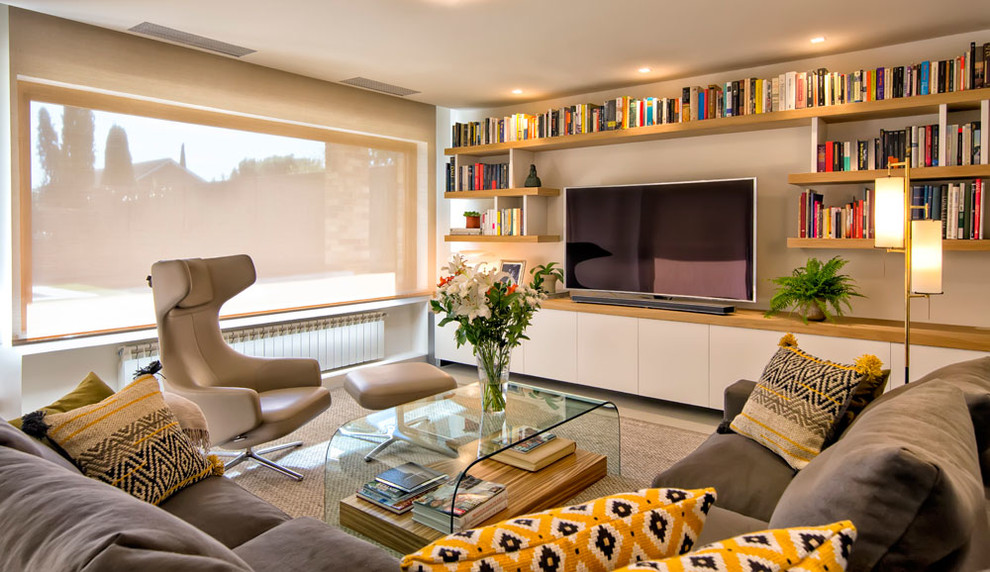 Inspiration for a mid-sized contemporary enclosed carpeted living room library remodel in Madrid with beige walls, no fireplace and a media wall