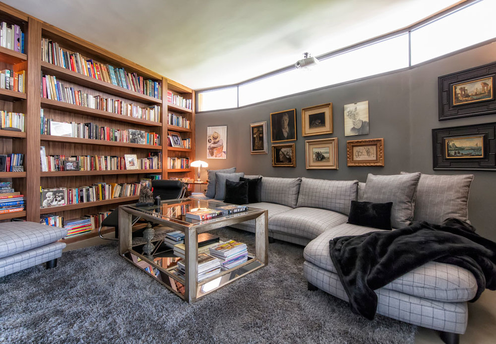 На фото: изолированная гостиная комната среднего размера в стиле фьюжн с с книжными шкафами и полками, серыми стенами и ковровым покрытием без камина, телевизора
