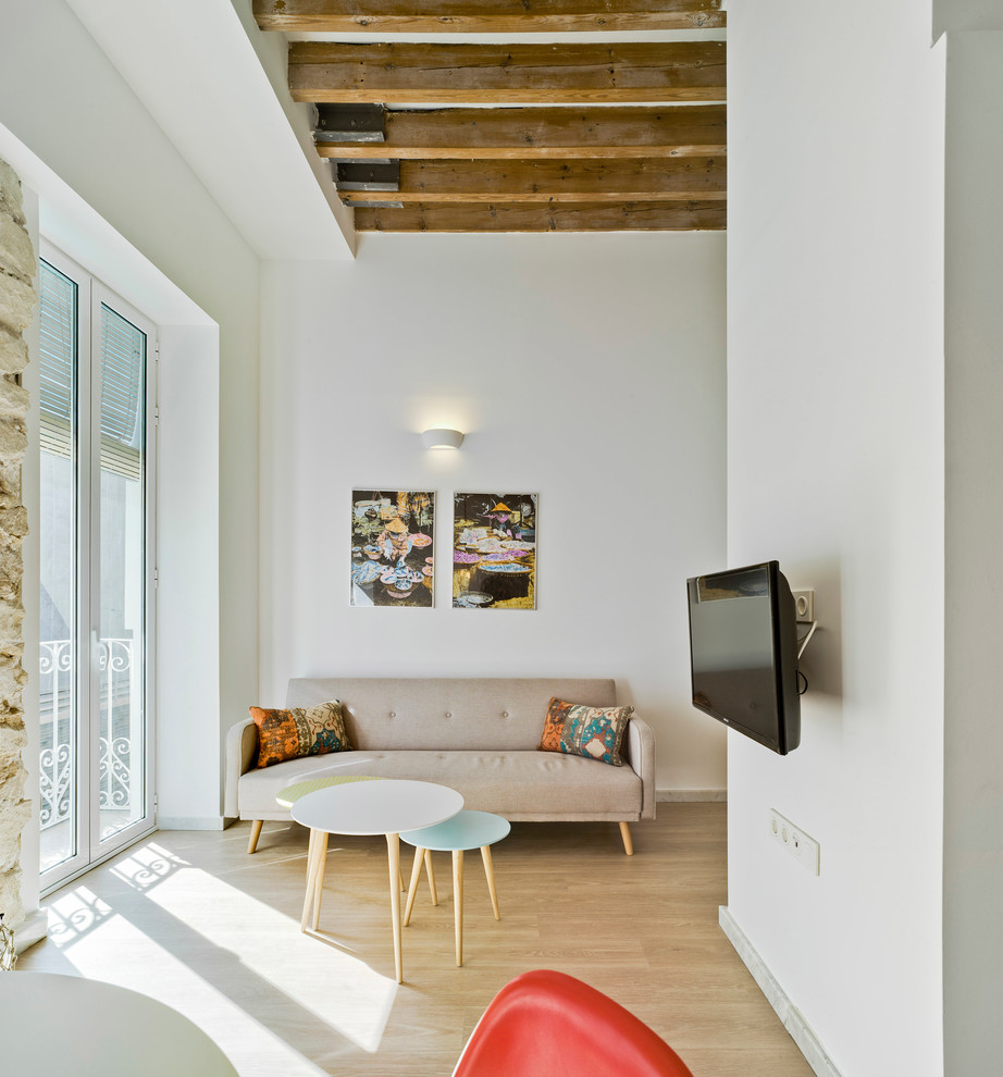 Идея дизайна: маленькая двухуровневая гостиная комната в средиземноморском стиле с музыкальной комнатой, белыми стенами, светлым паркетным полом и телевизором на стене для на участке и в саду
