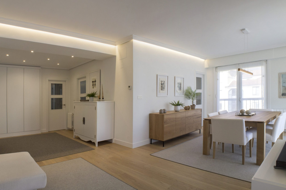 Idée de décoration pour un salon nordique de taille moyenne et ouvert avec un mur blanc, parquet clair, un téléviseur indépendant et un sol marron.
