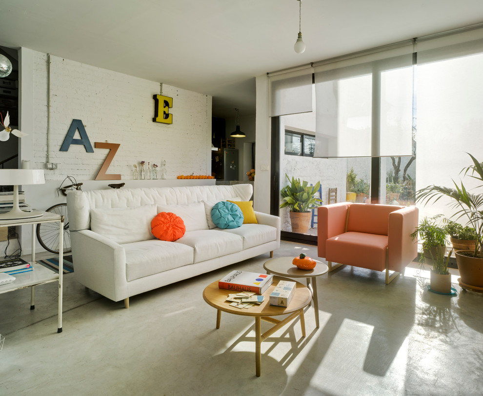 Großes, Repräsentatives, Fernseherloses, Offenes Modernes Wohnzimmer ohne Kamin mit weißer Wandfarbe und Betonboden in Sonstige
