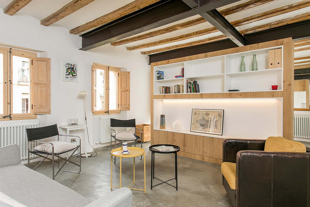 Ejemplo de salón abierto mediterráneo sin chimenea con paredes blancas, suelo de cemento y suelo gris