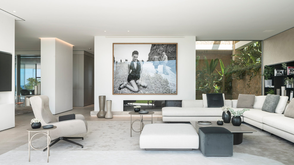 Imagen de salón abierto actual con paredes blancas, suelo de cemento y chimenea lineal
