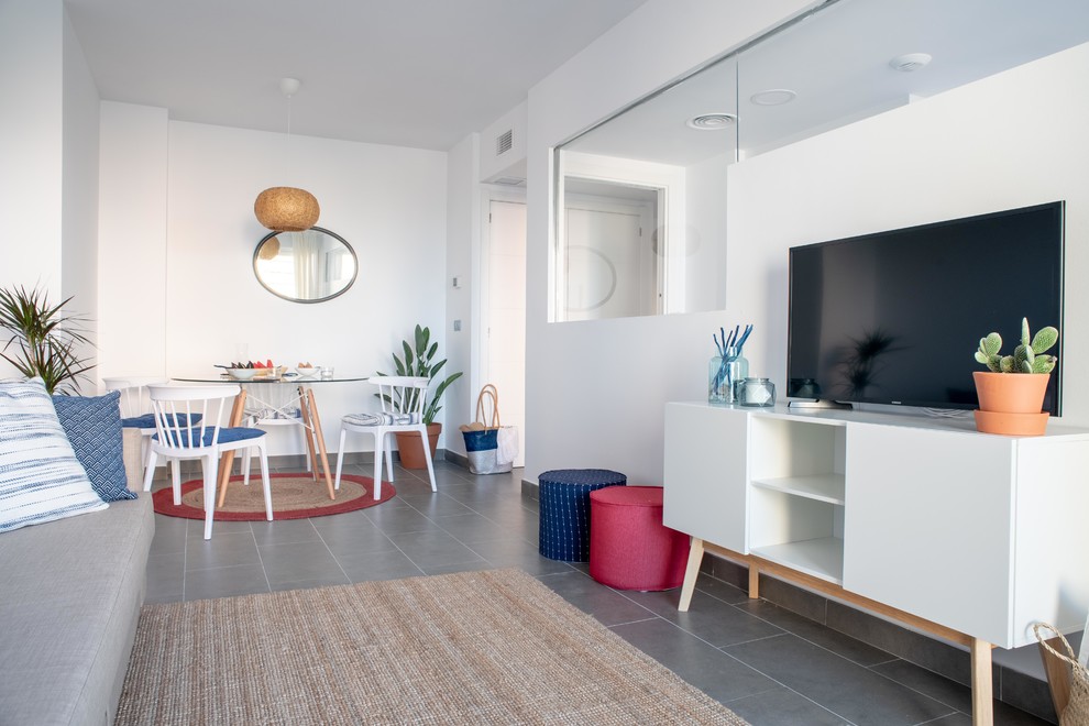 Foto di un soggiorno stile marinaro aperto con pareti bianche, TV autoportante, pavimento grigio e sala formale