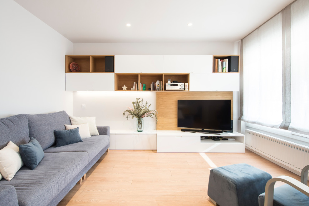 Idée de décoration pour un salon nordique ouvert avec un mur blanc, un sol en bois brun et un téléviseur d'angle.