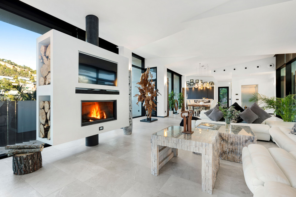 Стильный дизайн: открытая гостиная комната в современном стиле с белыми стенами, стандартным камином, телевизором на стене, серым полом и сводчатым потолком - последний тренд